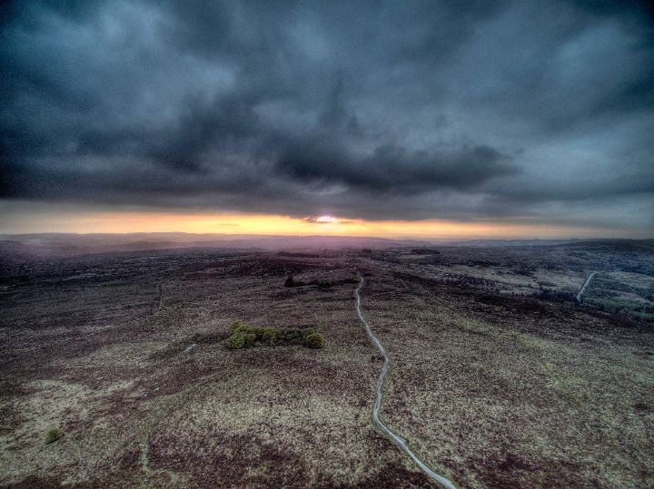 Une lande sombre au couchant, un chemin qui s’y perd sous un ciel chargé.